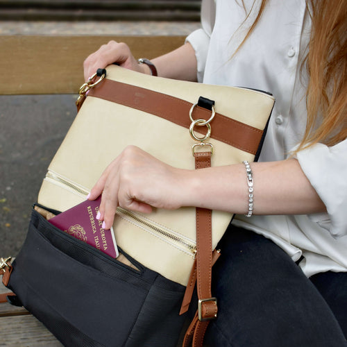 Woman takes out passport from beige convertible backpack