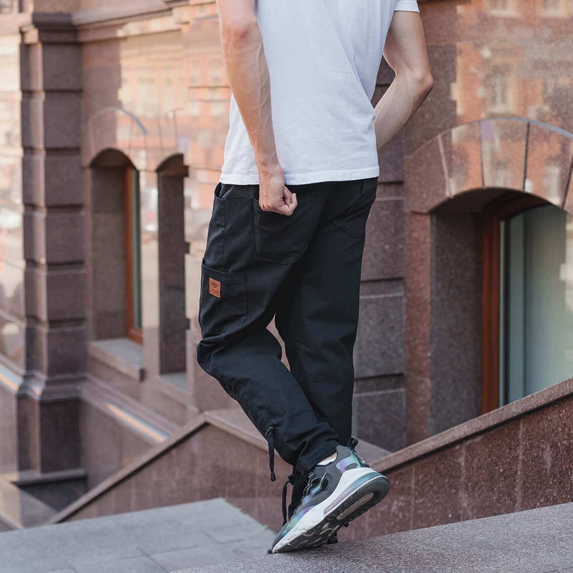 Man goes down the stairs with black travel pants