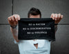person is holding his t-shirt black patch with the words - No to racism, No to discrimination, No to violence