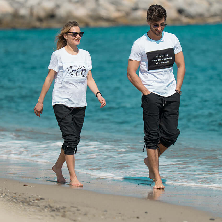 Man and woman stroll on the beach wearing adjustable-length pants